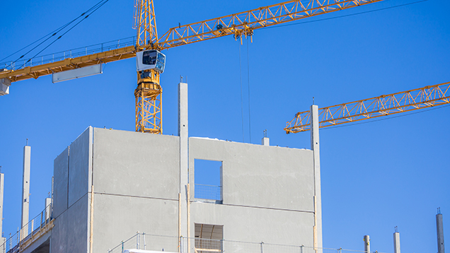 Kuvassa on nostokurki ja rakenteilla oleva talo.